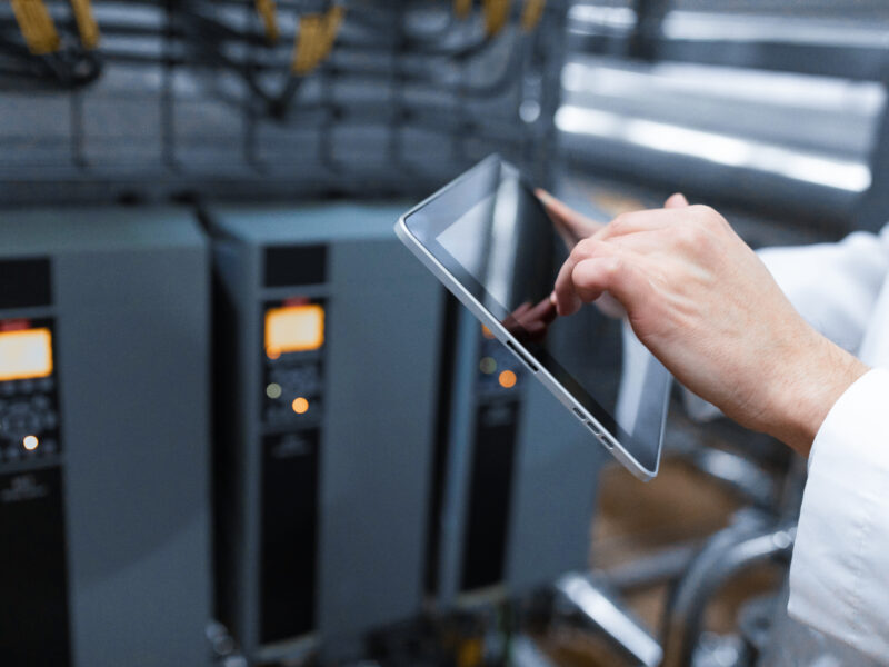 el tecnologo con una tableta gris en las manos prepara la linea de produccion mientras se encuentra en el departamento de la fabrica de productos lacteos